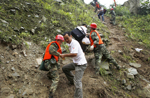 Rescuers help evacuate people trapped by landslides in Yingxiu town, southwest China's Sichuan Province on August 17, 2010. Landslides have driven locals to leave their homes for other cities in Sichuan such as Dujiangyan and Chengdu. 