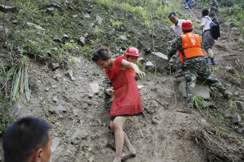 Rescuers help evacuate people trapped by landslides in Yingxiu town, southwest China's Sichuan Province on August 17, 2010.