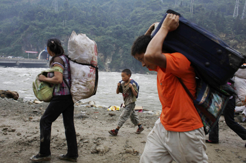 People leave their hometown at the upper side of a barrier lake in Yingxiu town, southwest China's Sichuan Province on August 17, 2010.