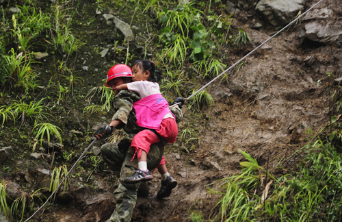 A rescuer helps a girl trapped by landslides in Yingxiu, southwest China's Sichuan Province on August 17, 2010. 