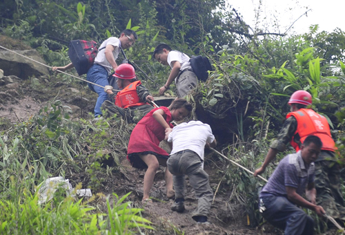 Rescuers help evacuate people trapped by landslides in Yingxiu town, southwest China's Sichuan Province on August 17, 2010.