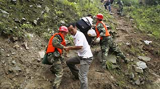 Rescuers help evacuate people trapped by landslides in Yingxiu town, southwest China's Sichuan Province on August 17, 2010. Landslides have driven locals to leave their homes for other cities in Sichuan such as Dujiangyan and Chengdu.