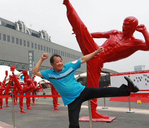 A tourist poses for photos in front of kungfu fighter statues at Expo Park, Aug 17, 2010. 
