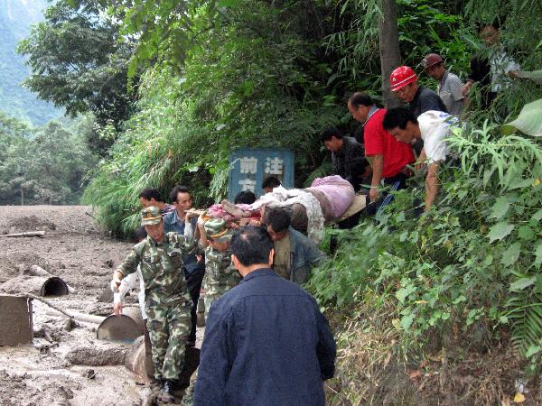 Rescuers carry an injured resident in mudslides-hit Puladi Township of Gongshan Drung-Nu Autonomous County, southwest China's Yunnan Province Aug. 18, 2010.