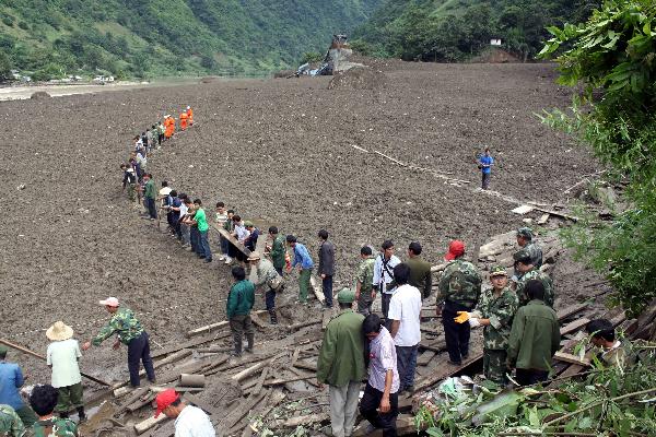 Rescuers and residents carry out the rescue work in mudslides-hit Puladi Township of Gongshan Drung-Nu Autonomous County, southwest China's Yunnan Province, Aug. 18, 2010.