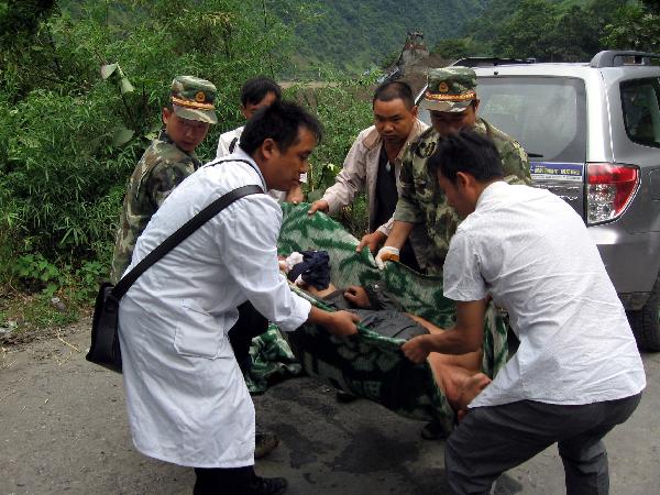 Rescuers carry an injured resident in mudslides-hit Puladi Township of Gongshan Drung-Nu Autonomous County, southwest China's Yunnan Province Aug. 18, 2010.