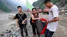 A mother and her son are ready to go over the mountain for Chengdu, from Wenchuan of southwest China's Sichuan Province, Aug. 18, 2010. The No. 213 National Highway linking Yingxiu and Wenchuan, known as the 'Lifeline' for the reconstruction of Wenchuan, was blocked by mudslides that hit Honggou Village of Yingxiu.