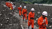 Rescuers walk in mudslides-hit Puladi Township of Gongshan Drung-Nu Autonomous County, southwest China's Yunnan Province, Aug. 19, 2010. Mudslides hit the township early Wednesday.