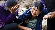 A sister-in-law of Zhang Honghong cries on the debris in Yueyuan Village, Zhouqu County, northwest China's Gansu Province, Aug. 18, 2010.