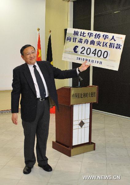 Chinese Ambassador to Belgium Zhang Yuanyuan shows a model of donation cheque during a charity donation by overseas Chinese in Belgium for mudslide-hit Zhouqu County of northwest China's Gansu Province, in Brussels, capital of Belgium, Aug. 19, 2010.