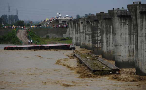 The fallen carriages are seen lying in the flooded river in Guanghan, Sichuan Province, August 19, 2010.