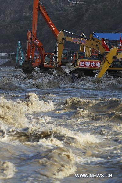  Cranes remove barriers to speed up flood discharge in landslide-hit Zhouqu County, Gannan Tibetan Autonomous Prefecture in northwest China's Gansu Province, Aug. 19, 2010. 