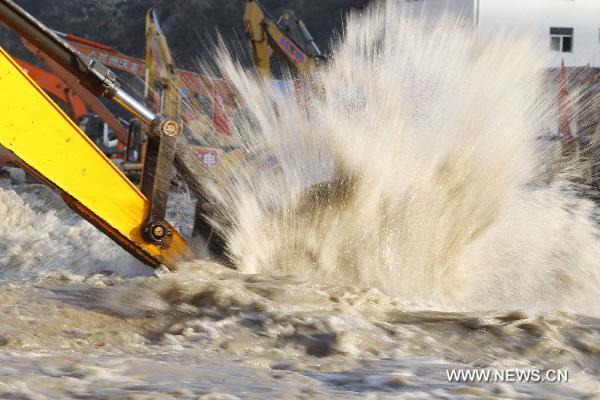 A crane removes barriers to speed up flood discharge in landslide-hit Zhouqu County, Gannan Tibetan Autonomous Prefecture in northwest China's Gansu Province, Aug. 19, 2010.