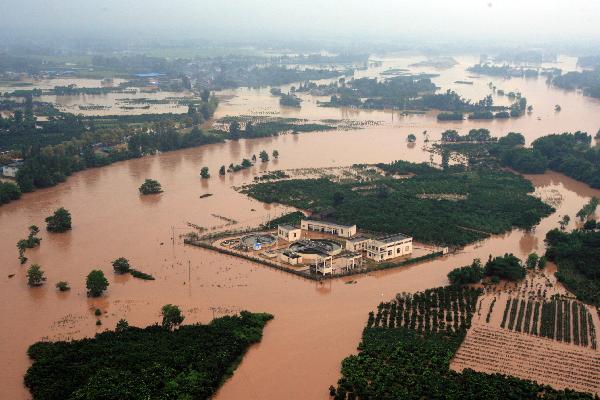 An aerial view taken from a helicopter shows the Wangchang village surrounded by flood in Pujiang County, Chengdu City, capital of southwest China's Sichuan Province, Aug. 19, 2010. 