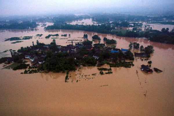 An aerial view taken from a helicopter shows the Wangchang village surrounded by flood in Pujiang County, Chengdu City, capital of southwest China's Sichuan Province, Aug. 19, 2010. 
