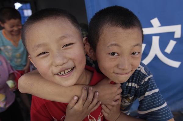 Two boys play outside a tent in the landslide-hit Zhouqu County, Gannan Tibetan Autonomous Prefecture in northwest China's Gansu Province, Aug. 19, 2010. 