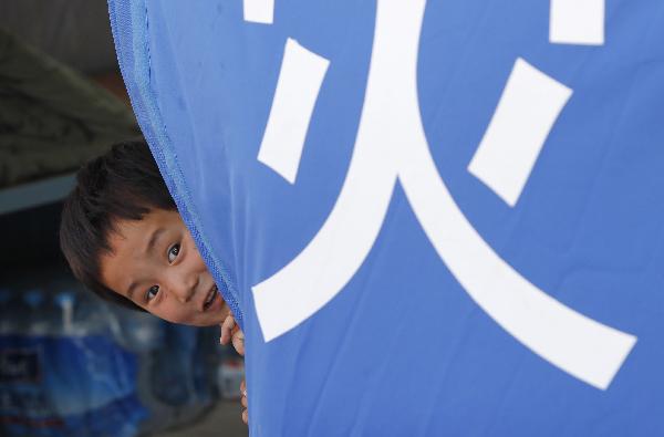 A girl plays in a tent in the landslide-hit Zhouqu County, Gannan Tibetan Autonomous Prefecture in northwest China's Gansu Province, Aug. 19, 2010.