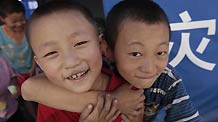 Two boys play outside a tent in the landslide-hit Zhouqu County, Gannan Tibetan Autonomous Prefecture in northwest China's Gansu Province, Aug. 19, 2010.