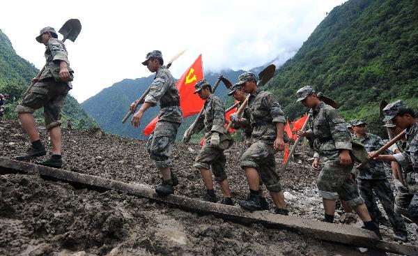 Rescuers walk in mudslides-hit Puladi Township of Gongshan Drung-Nu Autonomous County, southwest China's Yunnan Province, Aug. 19, 2010. 