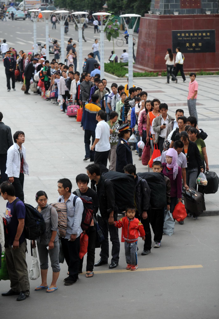 Workers wait to board a train bound for Xinjiang Uygur Autonomous Region at a railway station in Tianshui, northwest China's Gansu Province, Aug 20, 2010.