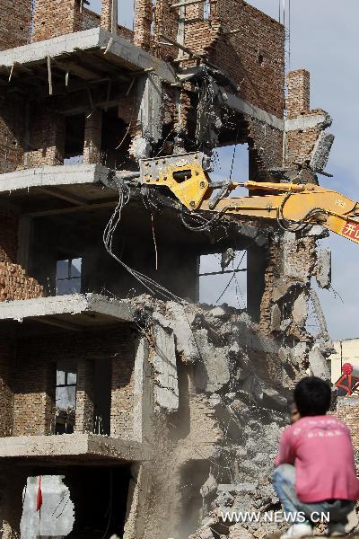 A crane demolishes a dilapidated building at the mudslide-hit Zhouqu County, Gannan Tibetan Autonomous Prefecture in northwest China&apos;s Gansu Province, Aug. 20, 2010. 