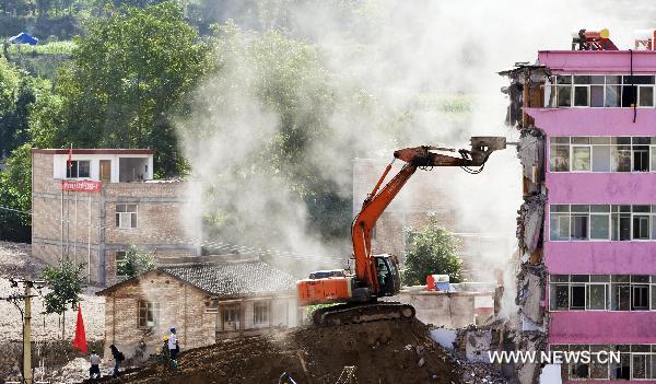 A crane demolishes a dilapidated building at the mudslide-hit Zhouqu County, Gannan Tibetan Autonomous Prefecture in northwest China&apos;s Gansu Province, Aug. 20, 2010.