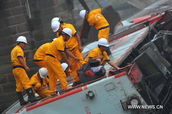 Workers take out luggages and belongings of passengers from a damaged carriage off the Baoji-Chengdu Railway in Xiaohan Township of Guanghan city, southwest China&apos;s Sichuan Province, Aug. 20, 2010. 