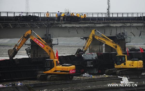 Workers disassemble the damaged carriage off the Baoji-Chengdu Railway in Xiaohan Township of Guanghan city, southwest China&apos;s Sichuan Province, Aug. 20, 2010.