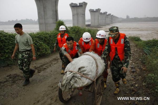 Workers take away luggages and belongings of passengers from a damaged carriage off the Baoji-Chengdu Railway in Xiaohan Township of Guanghan city, southwest China&apos;s Sichuan Province, Aug. 20, 2010. 
