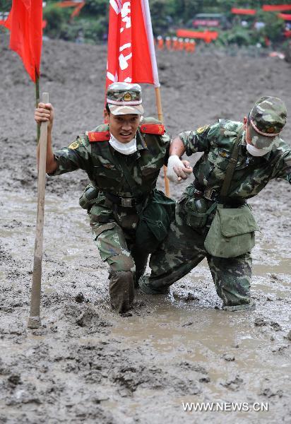 Rescuers struggle in sludge in mudslide-hit Puladi Township of Gongshan Drung-Nu Autonomous County, southwest China&apos;s Yunnan Province, Aug. 20, 2010.