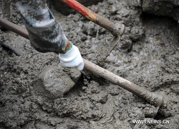 Rescuers clear off sludge in mudslide-hit Puladi Township of Gongshan Drung-Nu Autonomous County, southwest China&apos;s Yunnan Province, Aug. 20, 2010. 