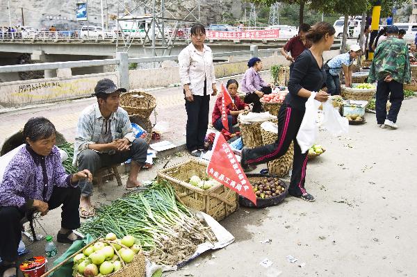 Residents sell vegetables on a street in the landslide-hit Zhouqu County, Gannan Tibetan Autonomous Prefecture in northwest China's Gansu Province, Aug. 20, 2010.