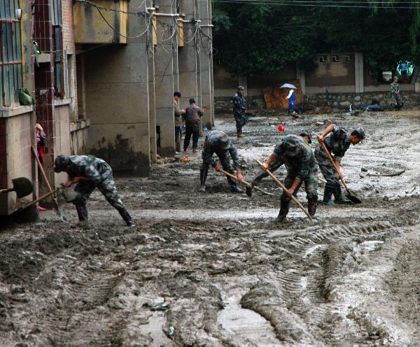 Soldiers clear mud at a community in Chengxian County of Longnan City, northwest China's Gansu Province, Aug. 20, 2010. Landslides and mudslides occurred in the city due to the heavy rains from Aug. 11. Twenty-three people were reported killed.