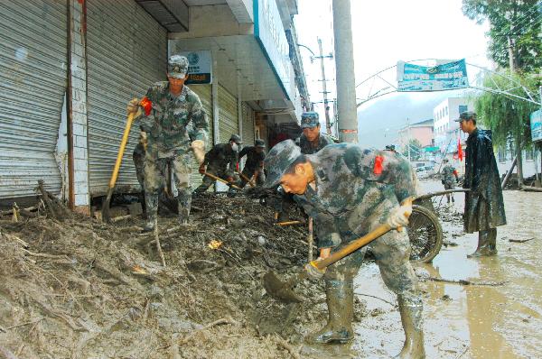 Soldiers clear the mud on a street in Huangzhu Township of Longnan City, northwest China's Gansu Province, Aug. 20, 2010. Landslides and mudslides occurred in the city due to the heavy rains from Aug. 11. Twenty-three people were reported killed.