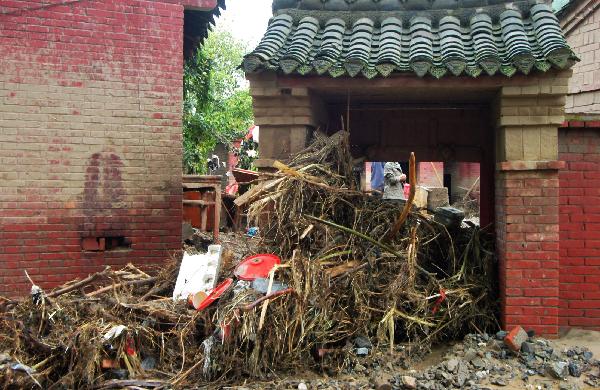 Branches of trees washed down by mudslides are seen at the door of a house in Huangzhu Township of Longnan City, northwest China's Gansu Province, Aug. 20, 2010. Landslides and mudslides occurred in the city due to the heavy rains from Aug. 11. Twenty-three people were reported killed.