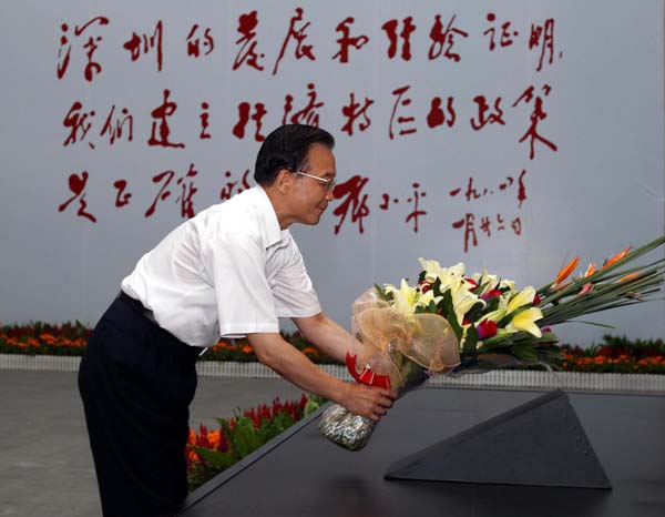Chinese Premier Wen Jiabao presents flowers to the sculpture of the late Chinese leader Deng Xiaoping in Shenzhen Museum, Shenzhen city, Guangdong Province August 21, 2010.