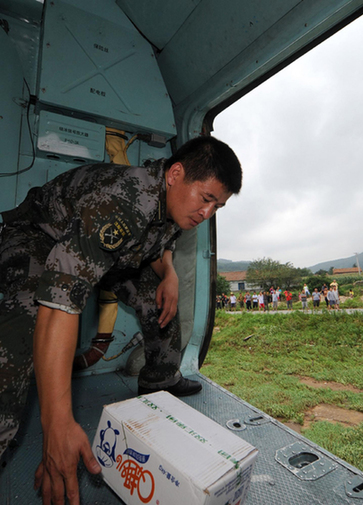 A soldier drops a box of food to a flooded village in Dandong on August 22, 2010. 