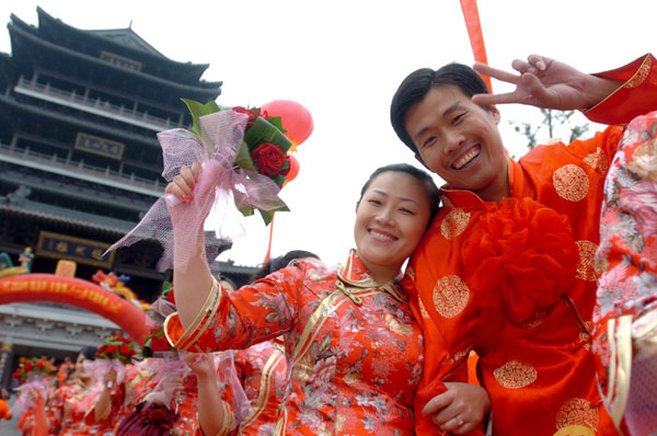 A couple poses for photos during a mass wedding ceremony in Jinan, Aug 22, 2010.