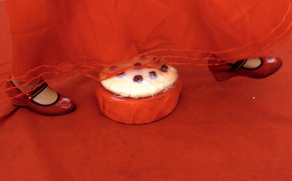 A bride strides a niangao (glutinous rice cake), with the connotation that &apos;everything goes better and better&apos;, during a mass traditional ceremony in Jinan, capital of east China&apos;s Shandong Province, Aug 22, 2010.