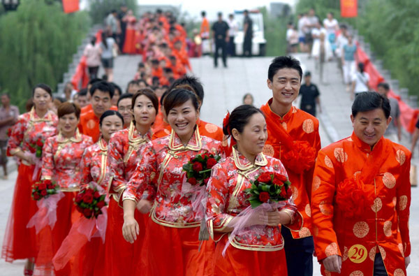 Newly-weds participate in a mass wedding ceremony wearing traditional embroidered wedding dresses on Sunday, Jinan, east China&apos;s Shandong Province.