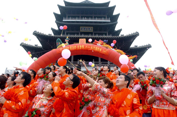 Couples wearing traditional embroidered wedding dresses release the &apos;balloons of wish&apos; on a mass wedding ceremony in Jinan, capital city of east China&apos;s Shandong Province, Aug 22, 2010. 