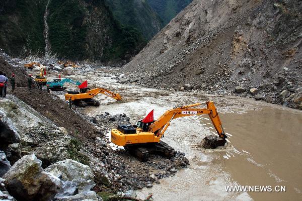 Cranes remove barriers to speed up flood discharge in landslide-hit Mianzhu City, southwest China's Sichuan Province, Aug. 21, 2010. 