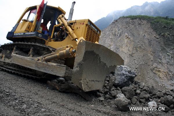 Cranes remove barriers on a road in landslide-hit Mianzhu City, southwest China's Sichuan Province, Aug. 21, 2010. 