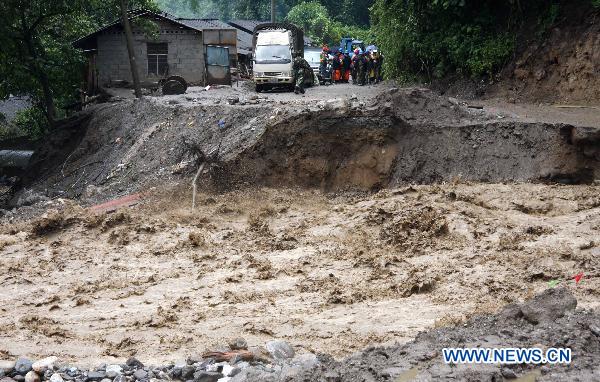 Torrential water of Dongyuegu River rushes across a damaged road in mudslide-hit Gongshan, southwest China's Yunnan Province, Aug. 22, 2010. 