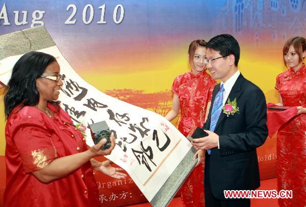 Delegates from China and Namibia exchange presents during the opening ceremony of Namibia Week at the 2010 World Expo in Shanghai, east China, Aug. 23, 2010. 