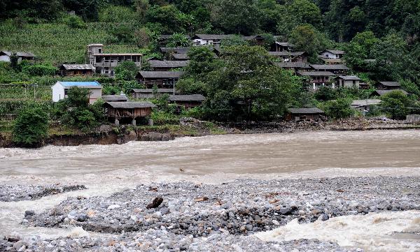 Flood water of Nujiang River flows closely to residences in a village of Gongshan, southwest China's Yunnan Province, Aug. 23, 2010.