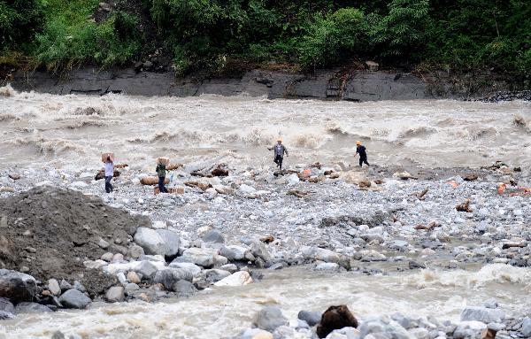 Workers emplace detonators for blowing up mud and stones to drain off flood water in Nujiang River in Gongshan, southwest China's Yunnan Province, Aug. 23, 2010.