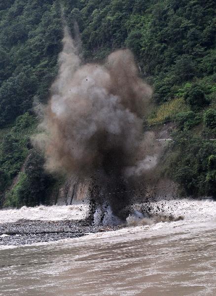 Detonators blow up mud and stones to drain off flood water in Nujiang River in Gongshan, southwest China's Yunnan Province, Aug. 23, 2010.