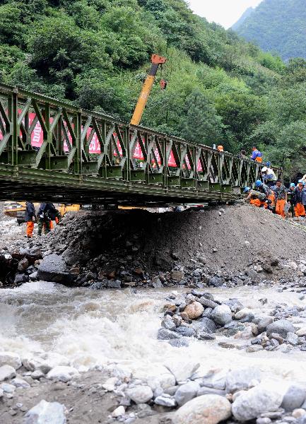 A steel bridge is built up across a river in Puladi Town in the mudslide-hit Gongshan, southwest China's Yunnan Province, Aug. 23, 2010.