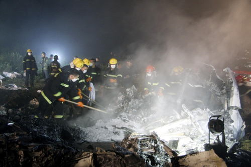 Rescuers work at the site of a reported plane crash at an airport in northeast China's Heilongjiang Province on Tuesday, August 24, 2010.